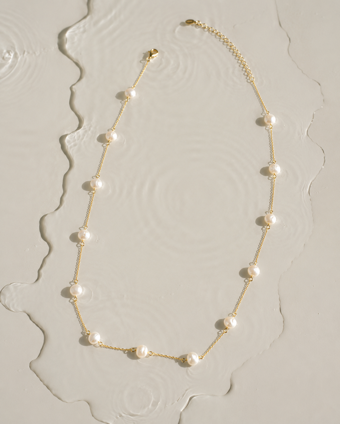 Gouden ketting Adria met parels gelegd in het water