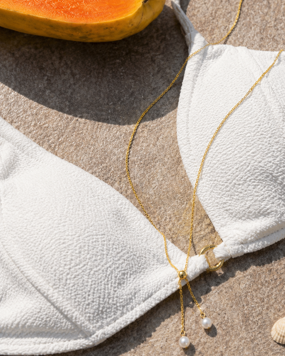 Gouden ketting Avela met parels in een strandsetting