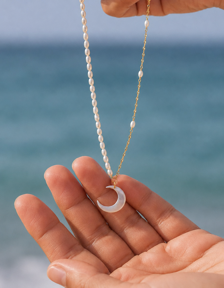 Gouden ketting Luna met parels en een maan vastgehouden in een hand