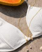 Gouden ketting Avela met parels in een strandsetting