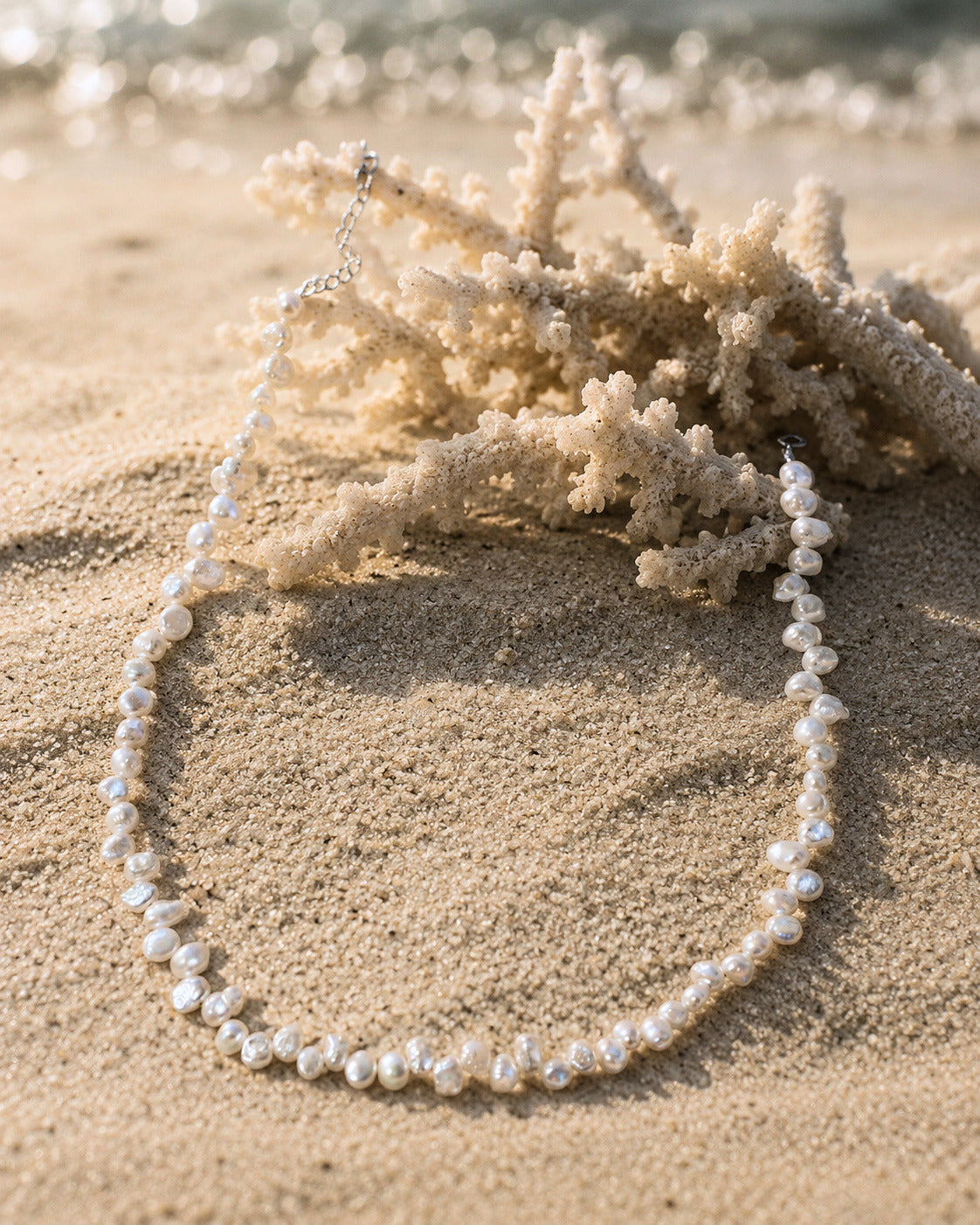 Ketting Cove van onregelmatige parels gelegd op het zand
